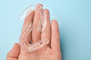 Close up of two Invisalign trays in the palm of a patient’s hand